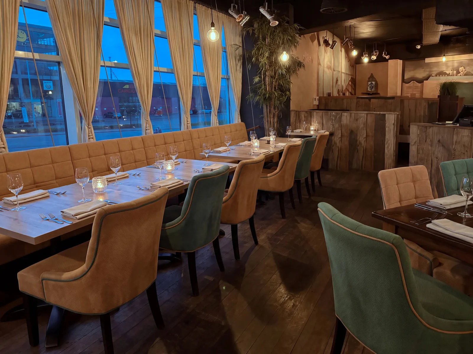 Lange rij gedekte tafels langs de oker bank en de ramen van AXXES